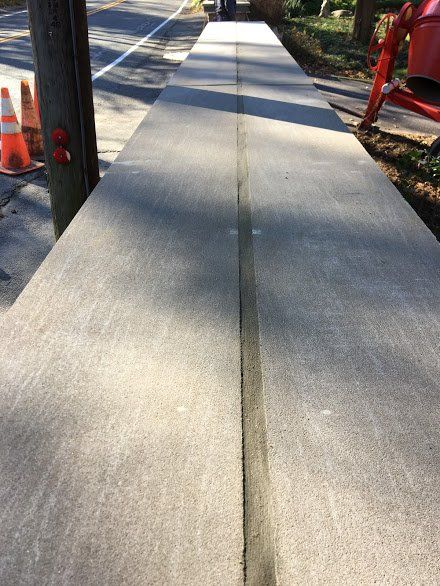 A concrete sidewalk is being built next to a road.