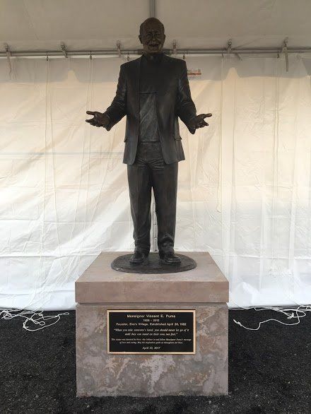 A bronze statue of a man with his arms outstretched