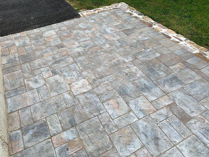 A close up of a brick walkway next to a grassy area.