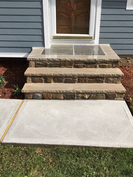 A set of stone steps leading up to the front door of a house.