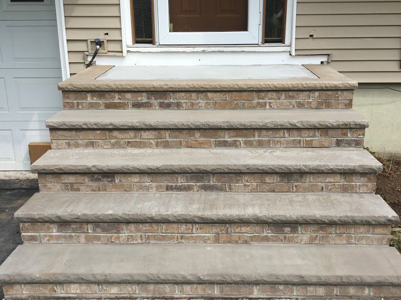 A set of stairs leading up to the front door of a house.