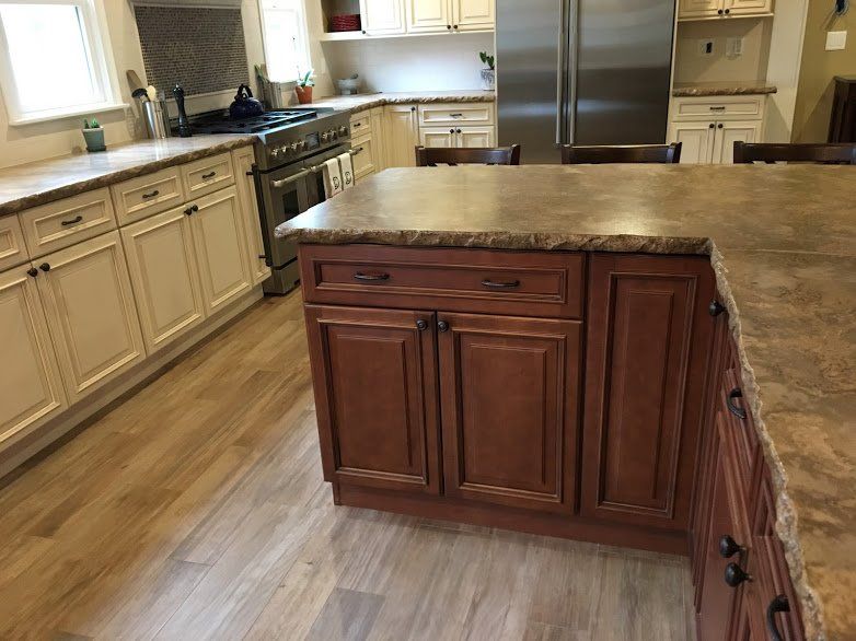 A kitchen with wooden cabinets , granite counter tops , stainless steel appliances and a large island.