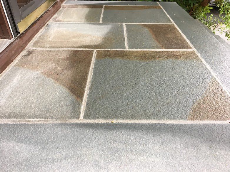 A gray and brown tile floor with a white border