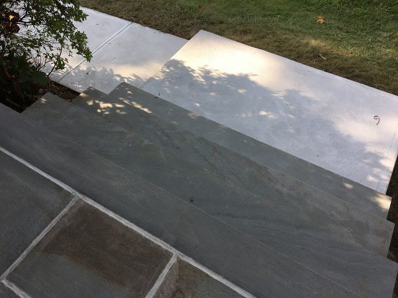 An aerial view of a concrete driveway with a tree in the background
