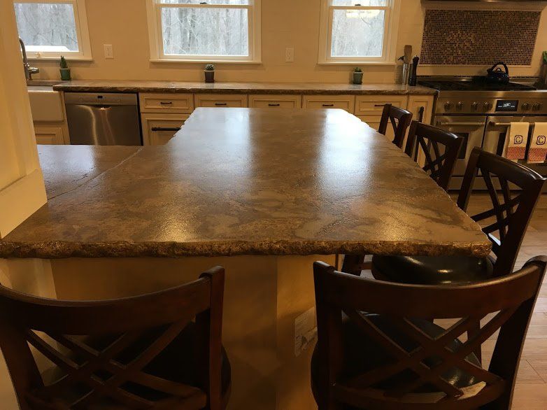 A kitchen with a large island and chairs