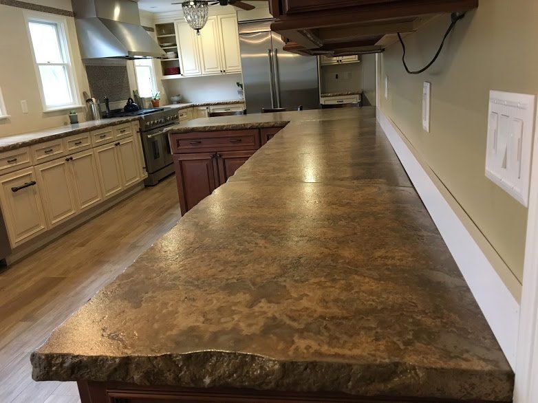 A kitchen with a long counter top and stainless steel appliances