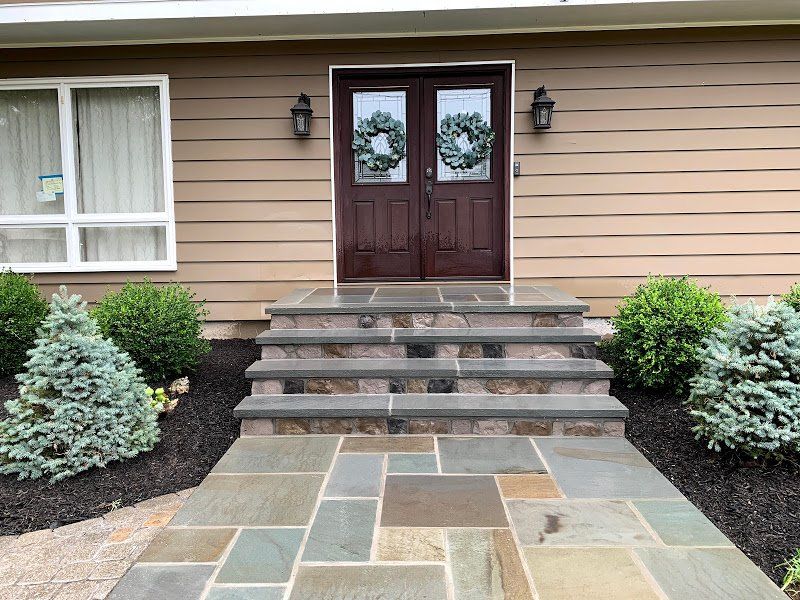 A house with a stone walkway leading to the front door.