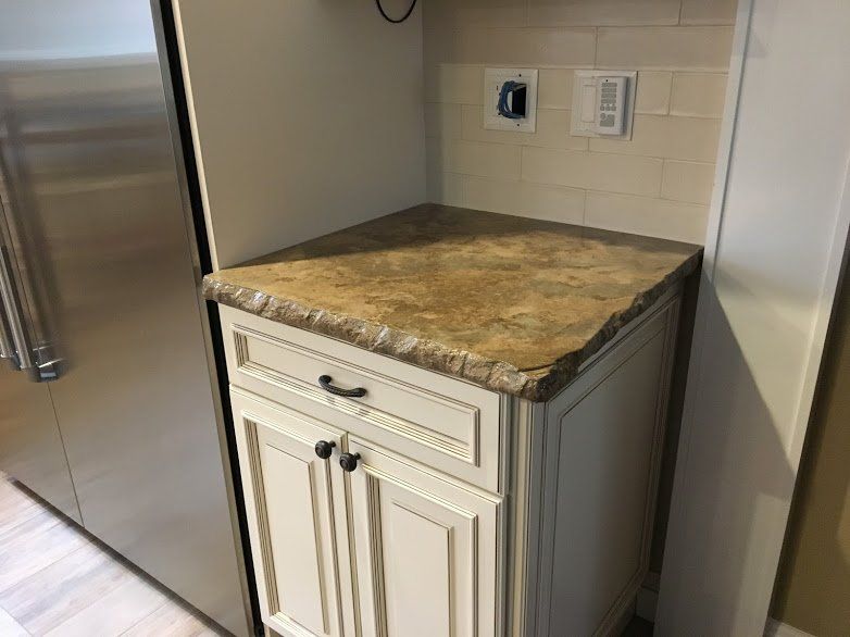 A kitchen with white cabinets and a granite counter top.