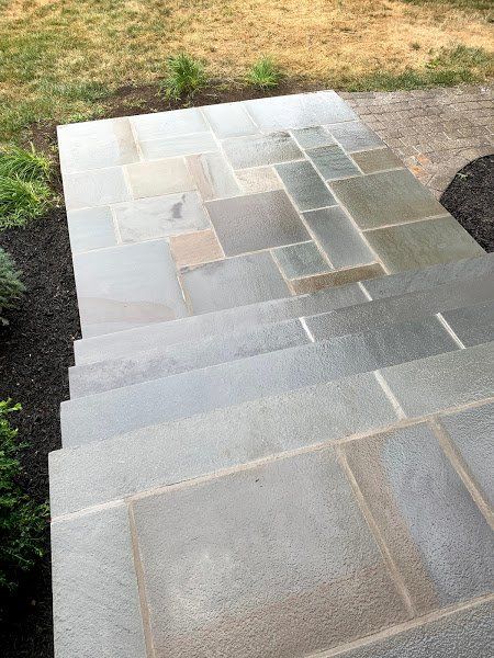A set of stone stairs leading up to a lawn.