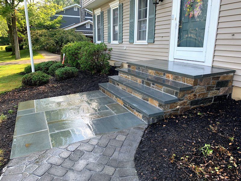 A stone walkway leading to the front door of a house.