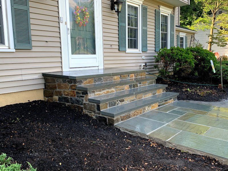 A house with stone steps leading up to the front door.