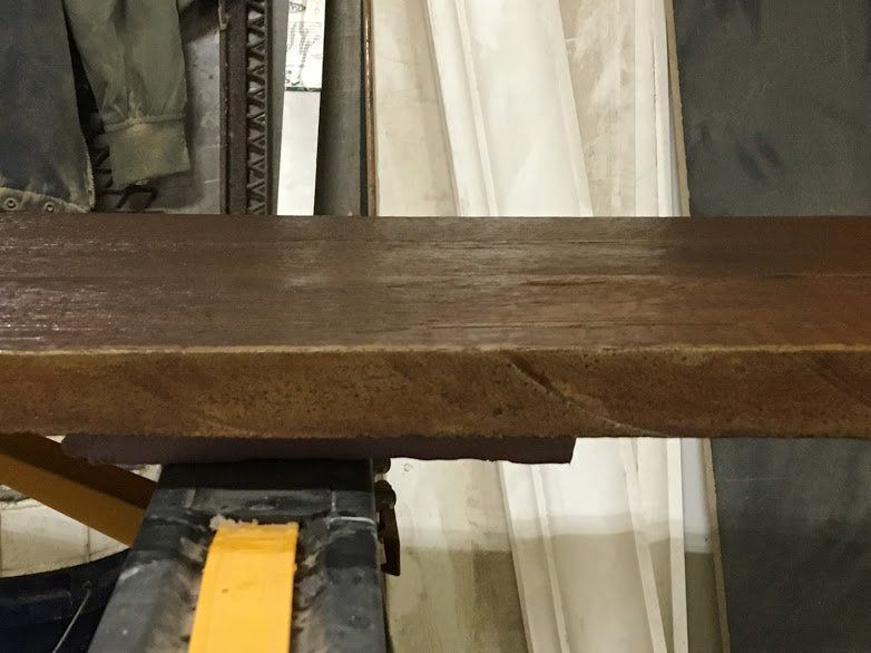 A piece of wood is sitting on top of a yellow block.