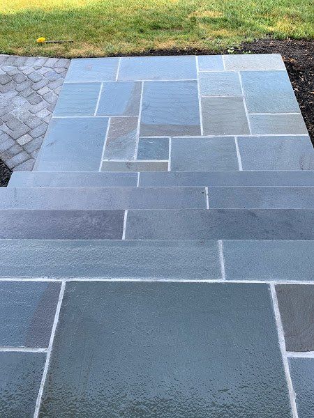 A stone walkway with steps leading up to a grassy area