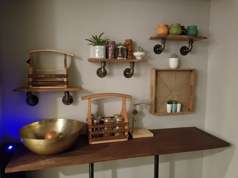 A wooden table with a bowl on it and shelves behind it.
