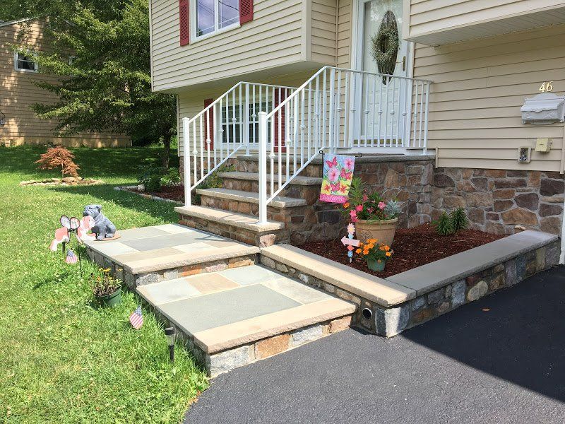 A house with stairs leading up to the front door.