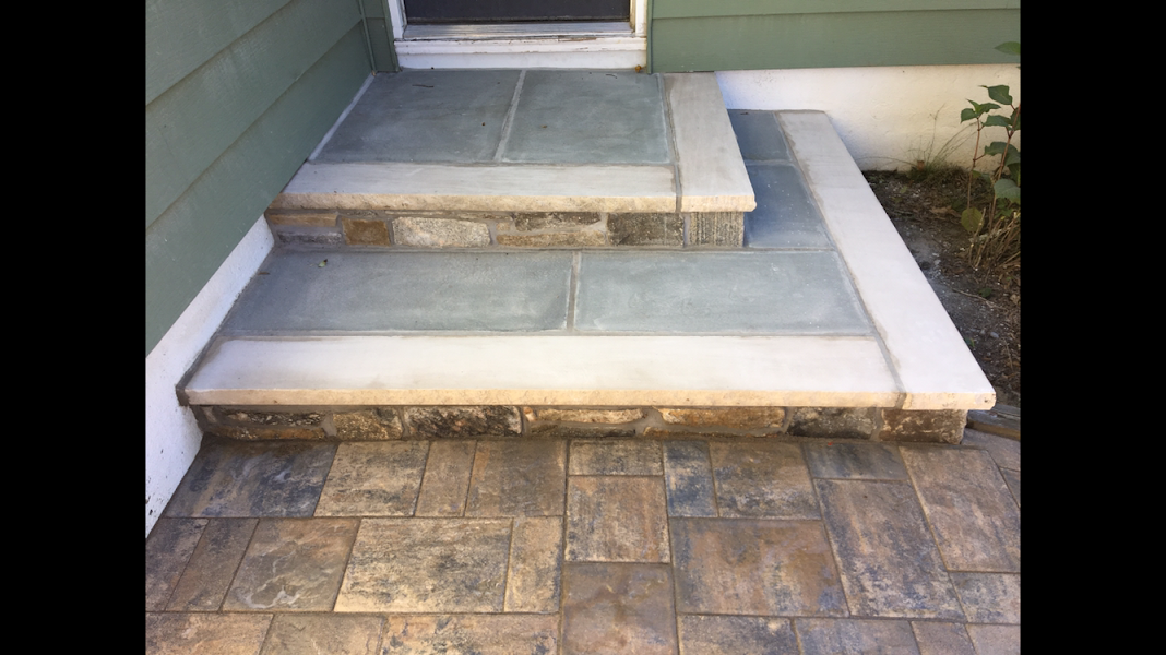 A set of stone steps leading up to a doorway of a house.