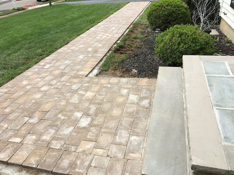 A brick walkway is being built in front of a house.
