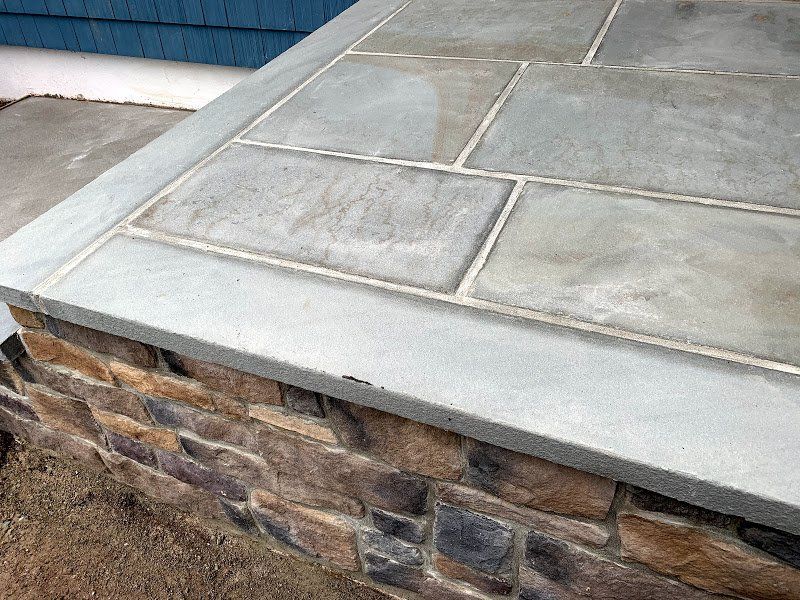A brick wall with a concrete ledge on top of it.