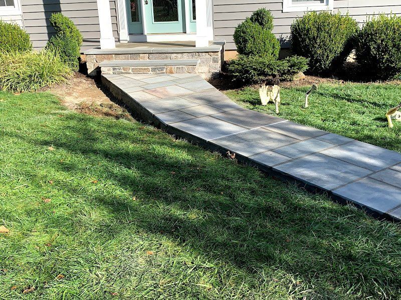 A concrete walkway leading to the front door of a house.