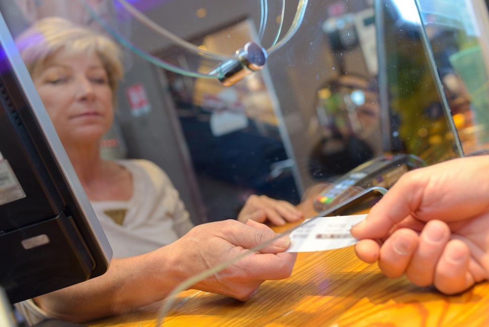 Man hands ticket over to a women at a ticketboth