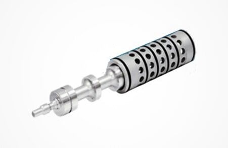 Rotor o componente de turbina mecánico metálico con carcasa cilíndrica perforada sobre fondo blanco.