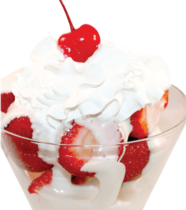 Strawberry sundae with whipped cream and cherry in a glass.