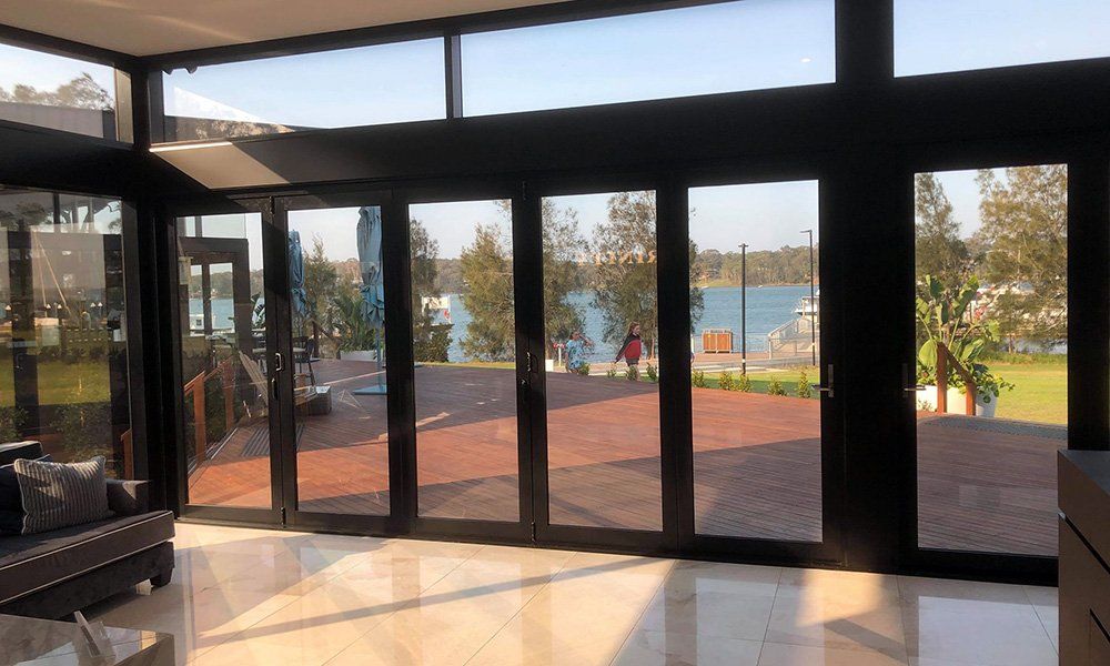 A living room with a lot of windows and a view of a lake