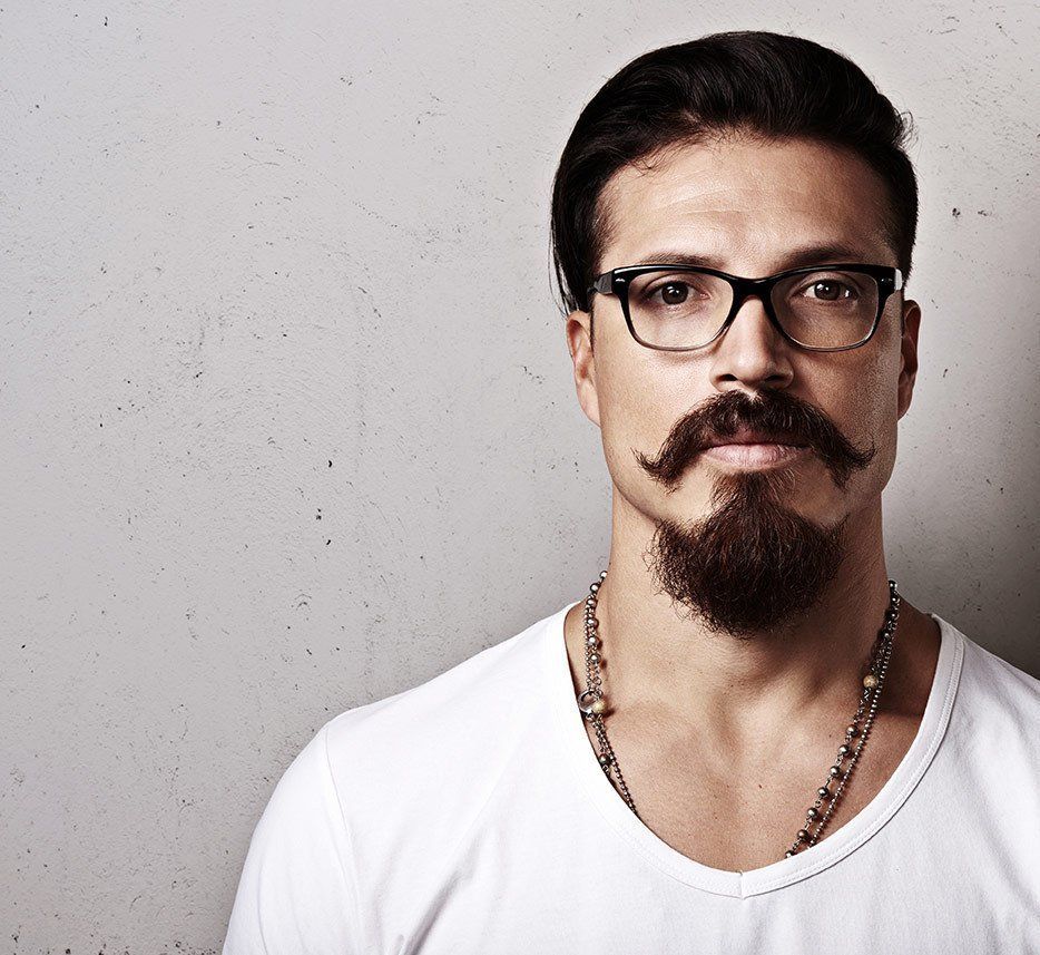 A man with glasses and a beard poses for the camera.