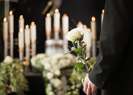 Cremation Urns Service — Man Holding A White Rose At Funeral In Cheektowaga, NY