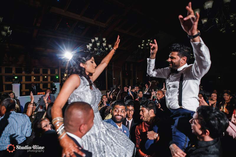 bride and groom raised up on shoulders