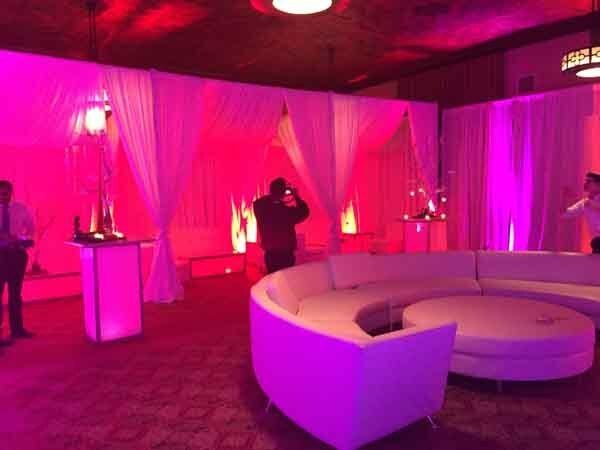 white curved couch with pink lighting