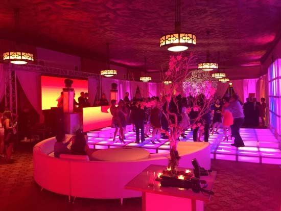 white lounge furniture in a large room with party lights and people dancing