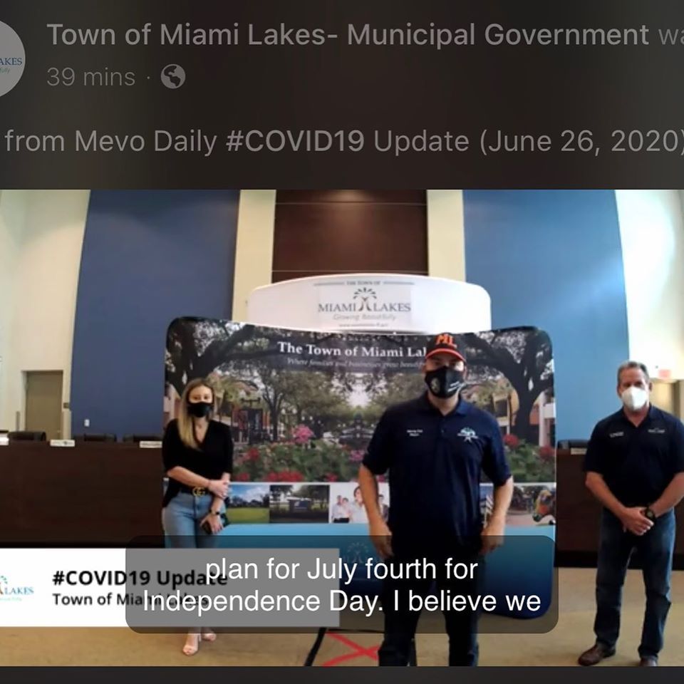 Three people in front of a Miami Lakes sign, discussing a COVID-19 update and July 4th plans.