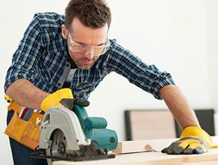 Focus Carpenter Sawing Wood Board — Contractors Tools & Fasteners in Fresno, CA Focus Carpenter Sawing Wood Board — Contractors Tools & Fasteners in Fresno, CA
