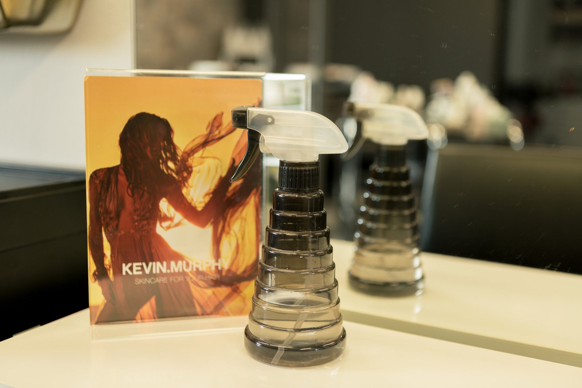 Auf einem Tisch steht neben einer CD von Kevin Murphy eine Sprühflasche.