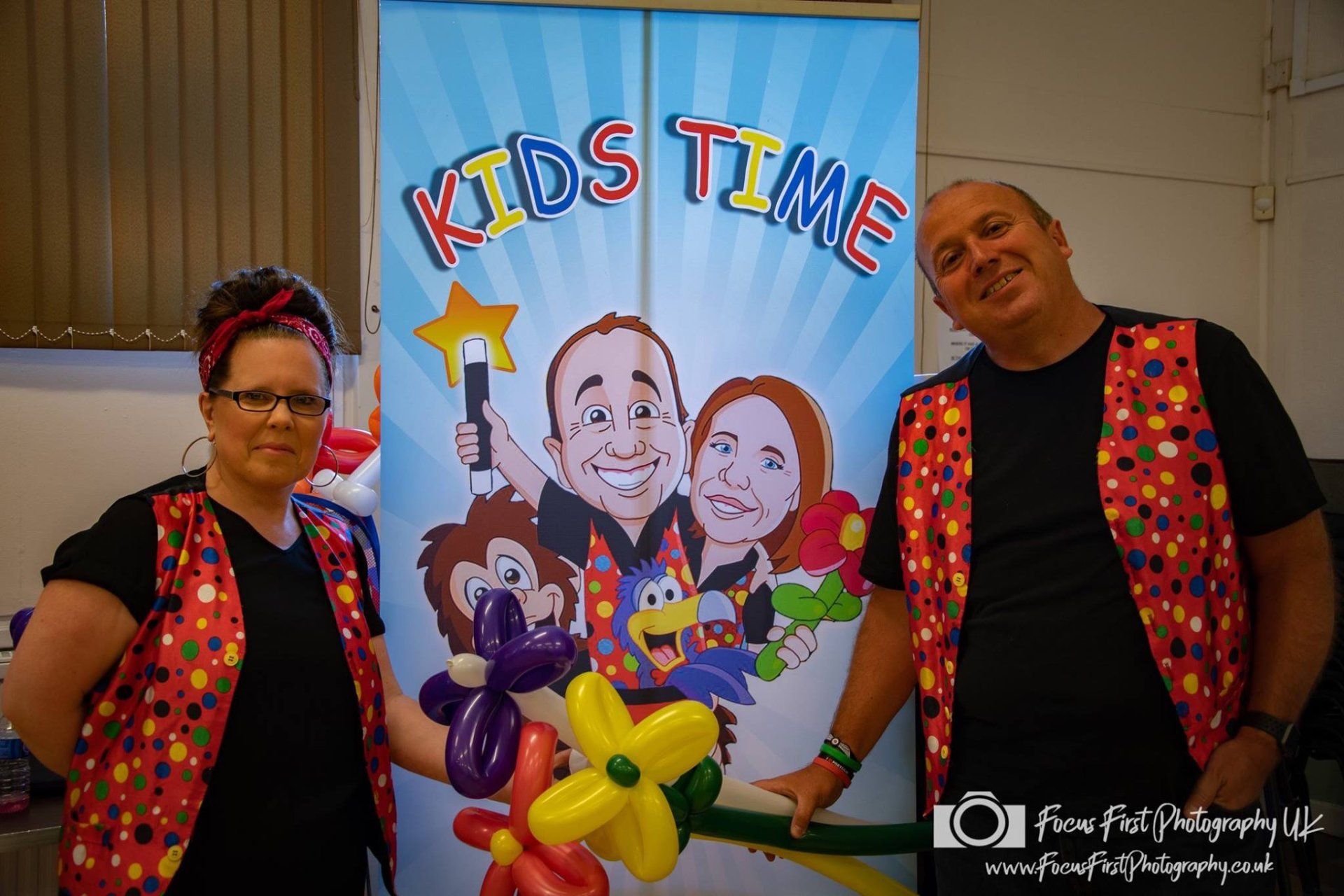 Derek and Suzanne posing with the Kidstime banner