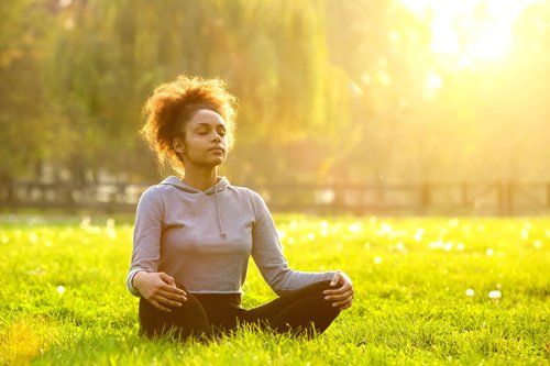 woman meditating in field woman meditating in field