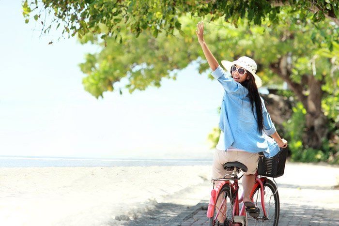 Happy woman waving on bike happy woman waving on bike