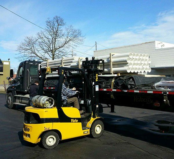 Forklift carrying pipes