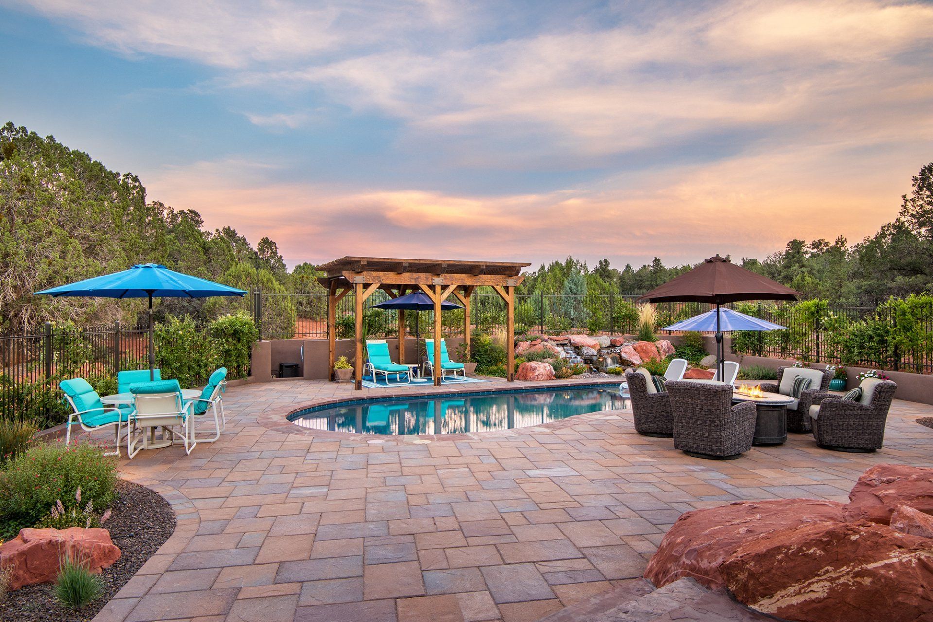 A large swimming pool surrounded by patio furniture and umbrellas.