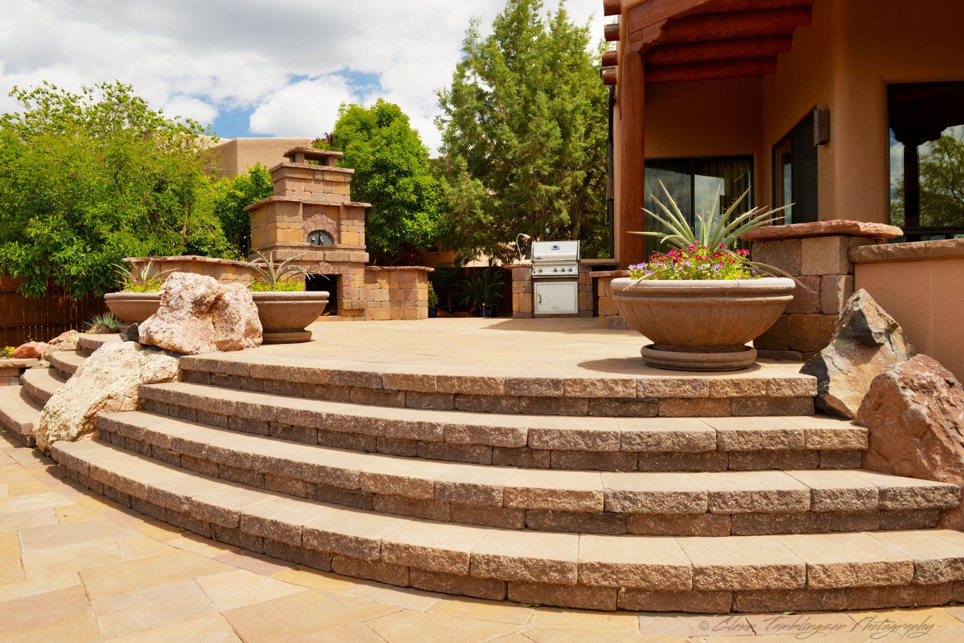 A set of stairs leading up to a patio in front of a house.