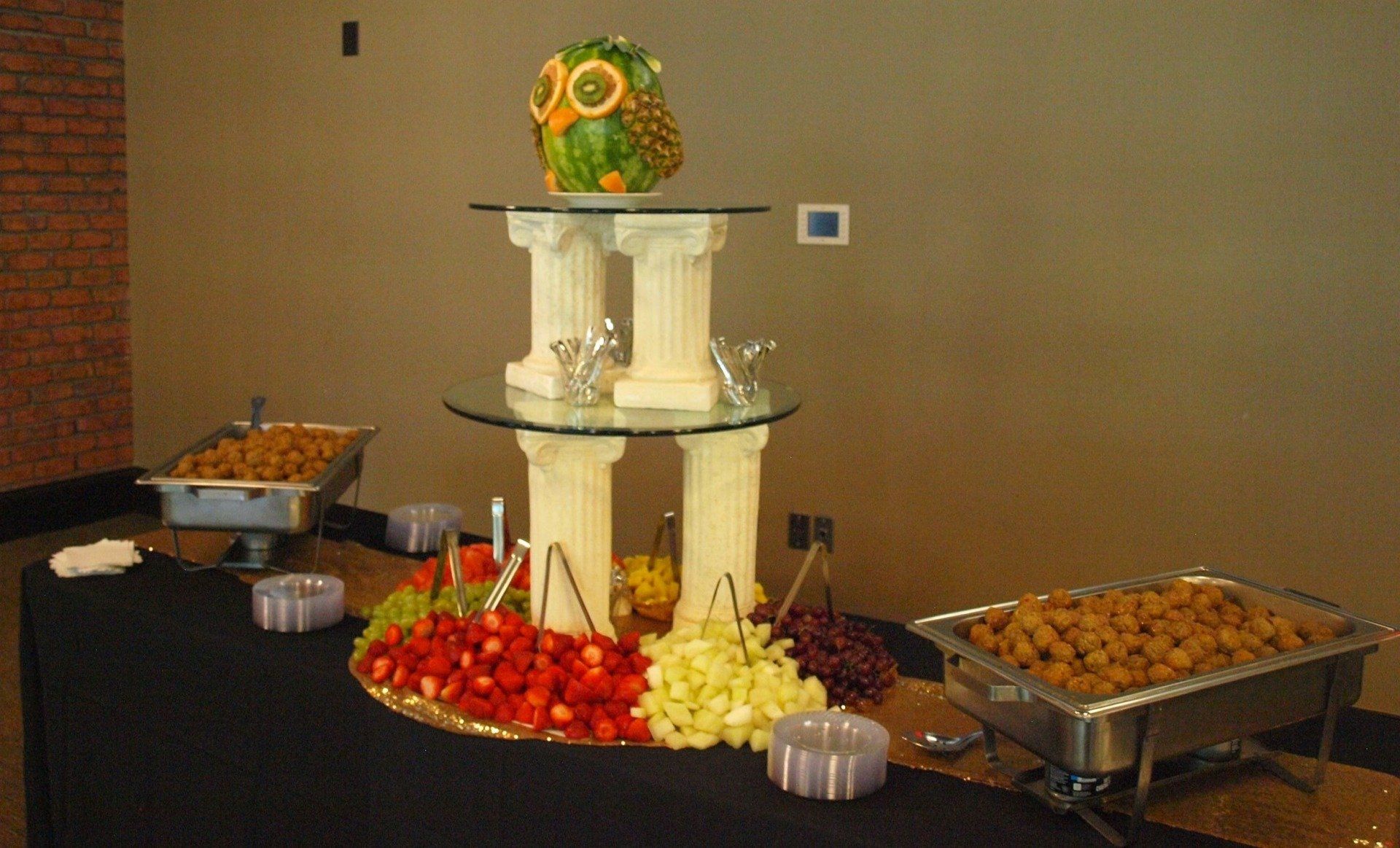 3 tiered centerpiece display of fruit with owl statue on top