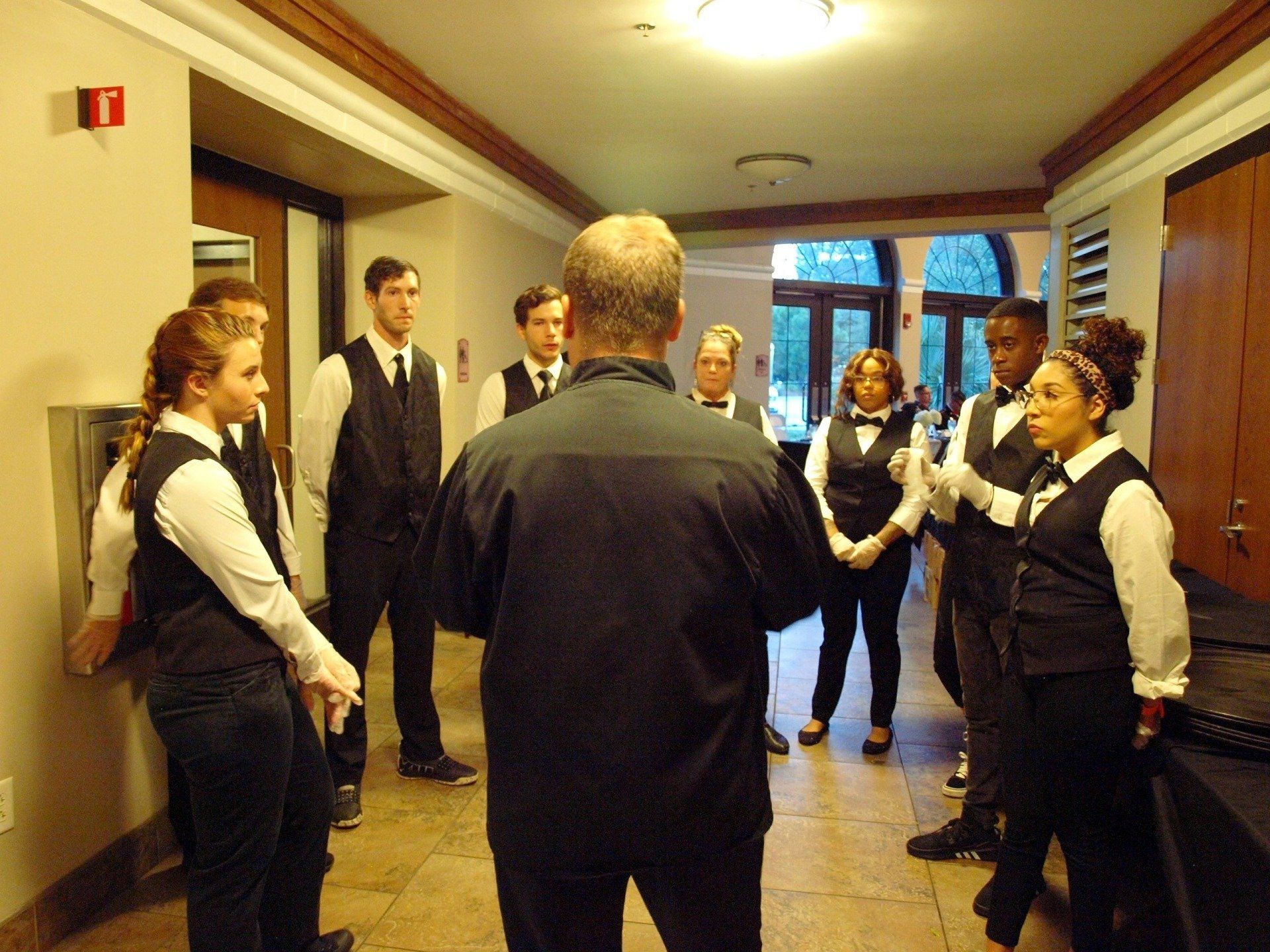 a group of caterers receiving instruction before an event