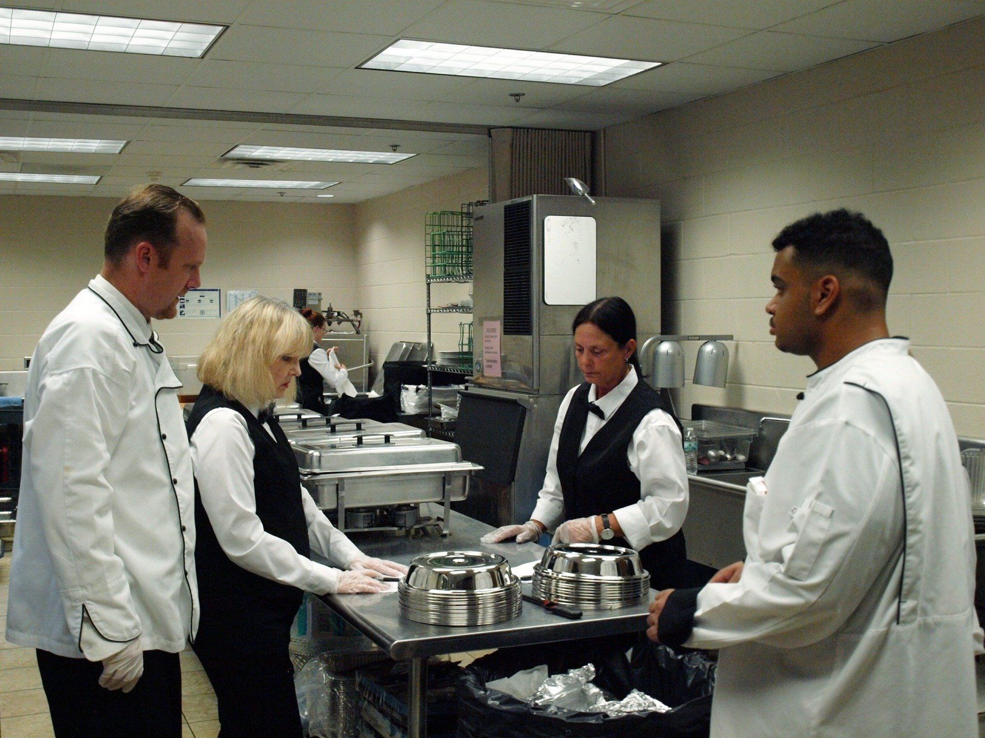 some caterers preparing in kitchen