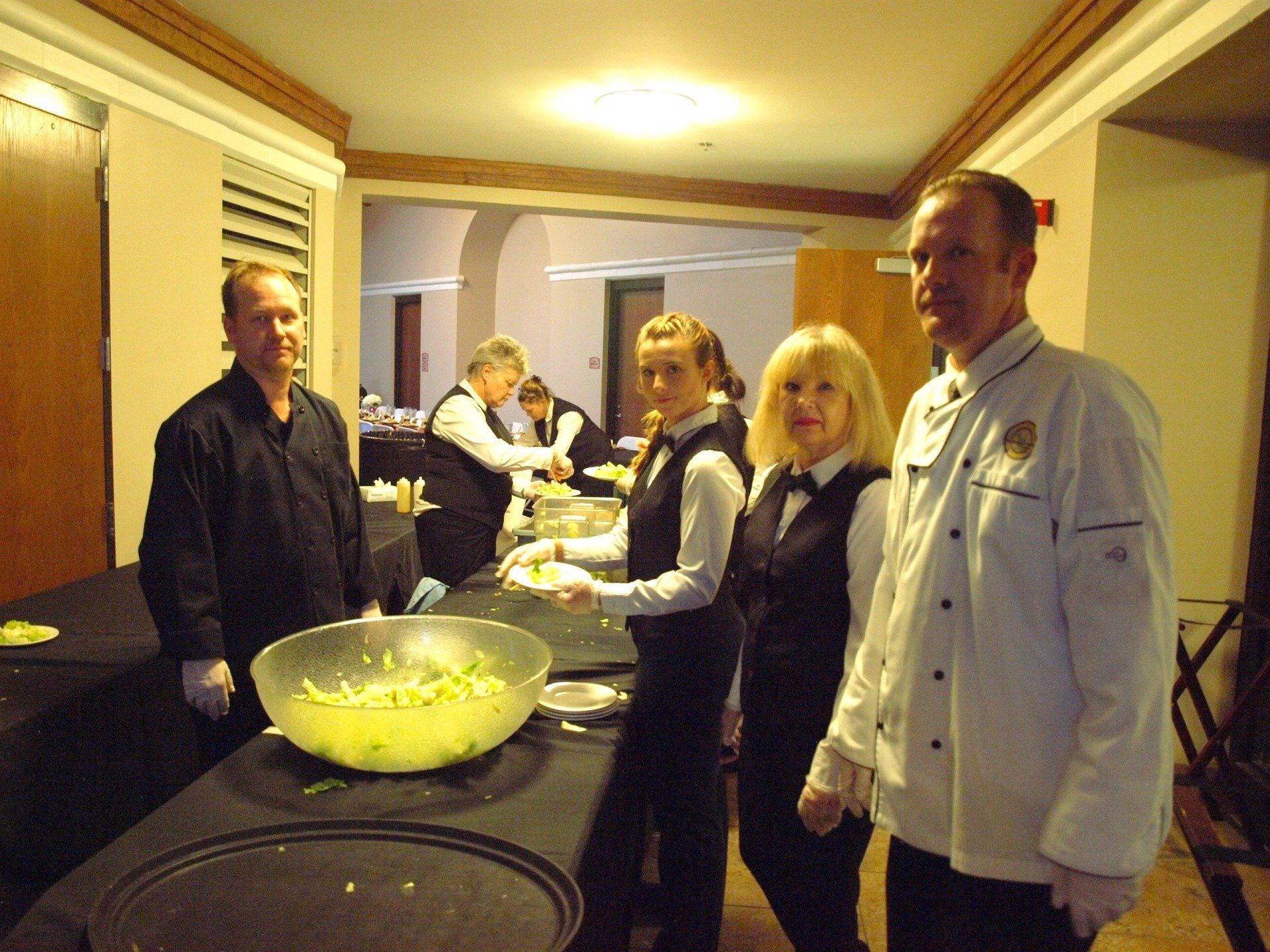 a group of caterers working a buffet table