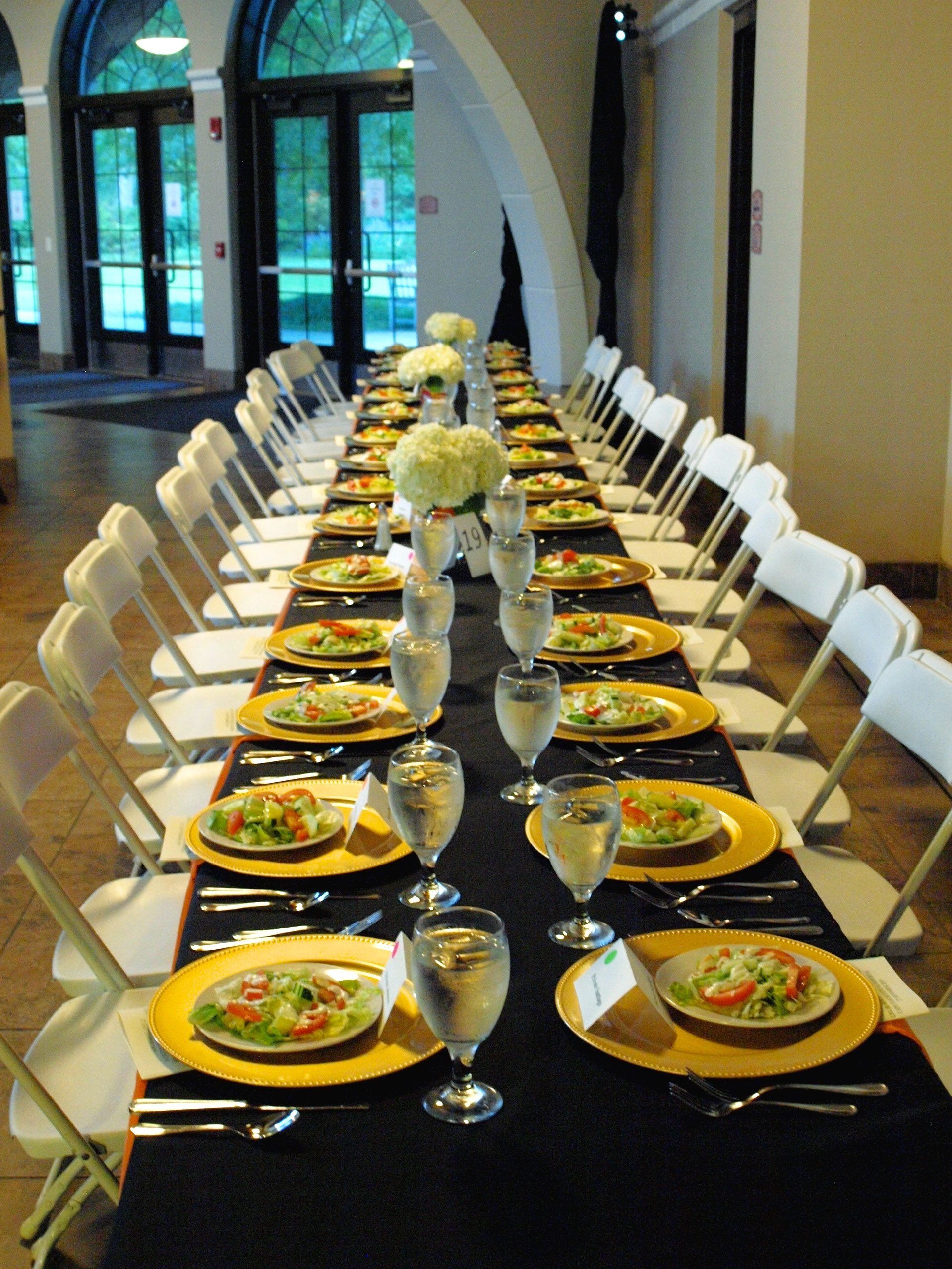 long rectangular table set with plated salads