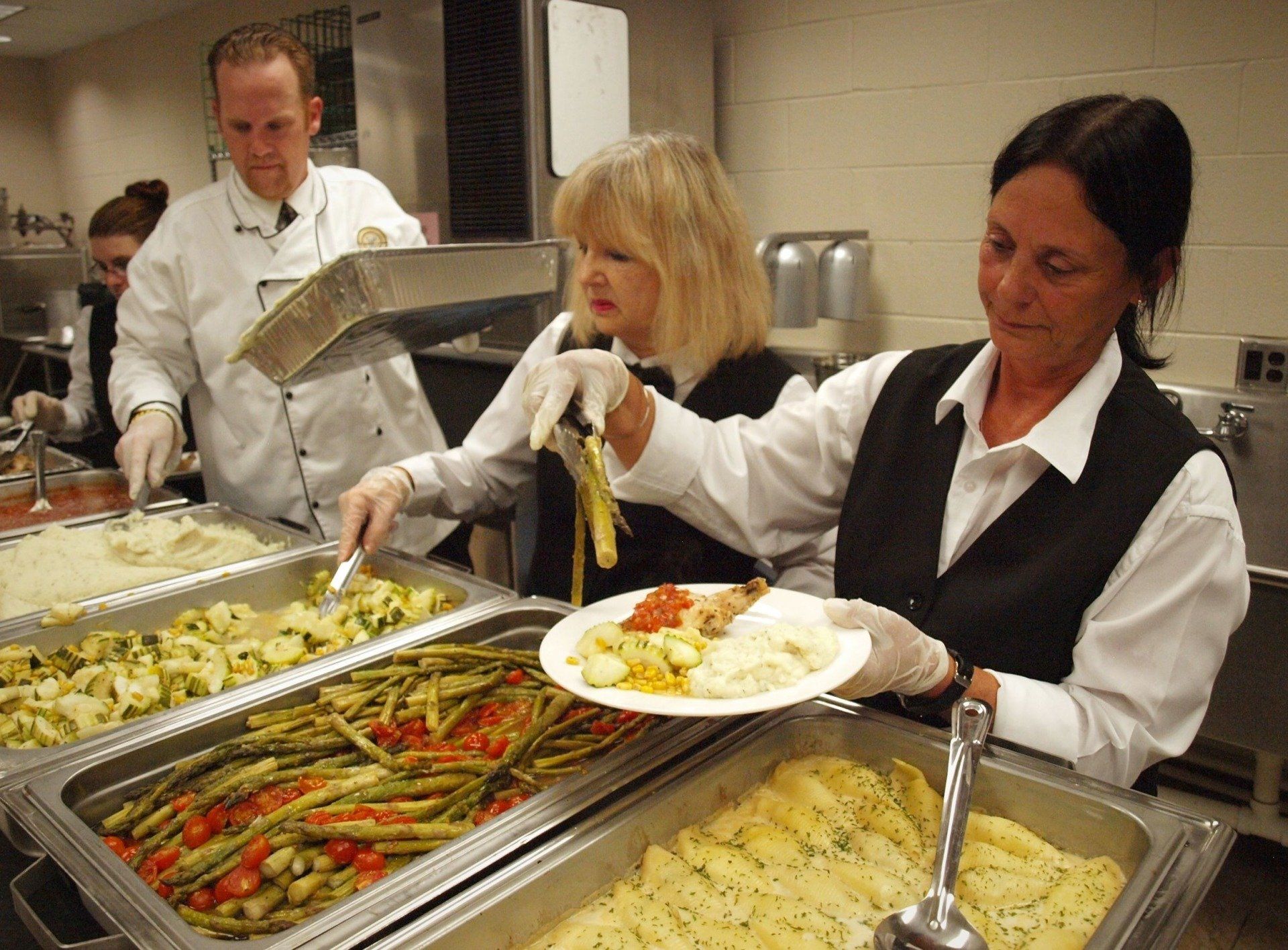 caterers plating food from a buffet
