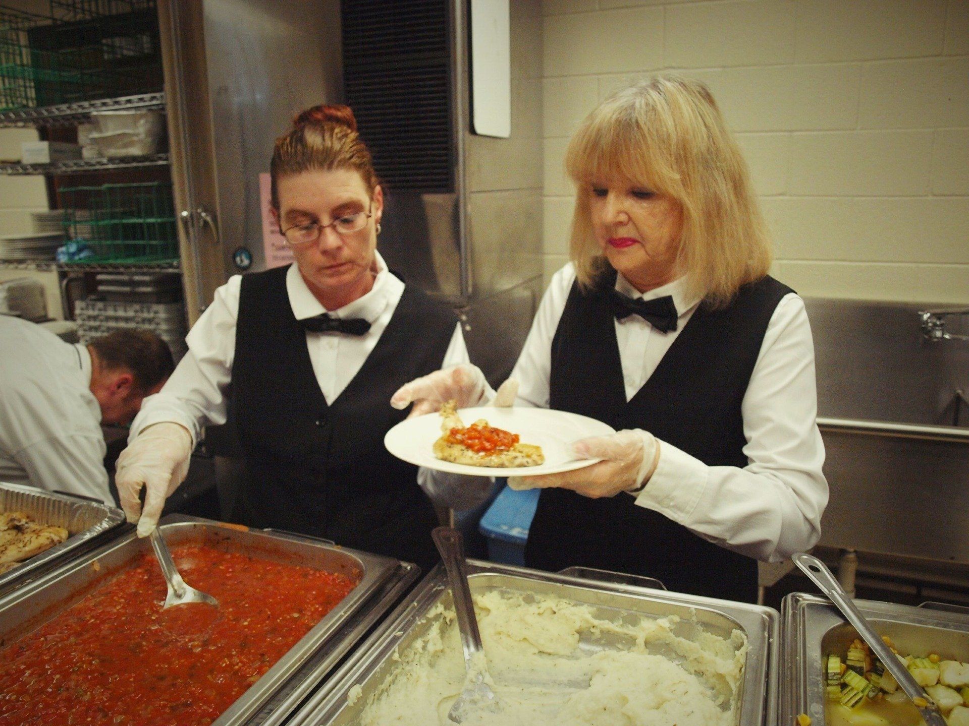 female caterers putting food on a plate