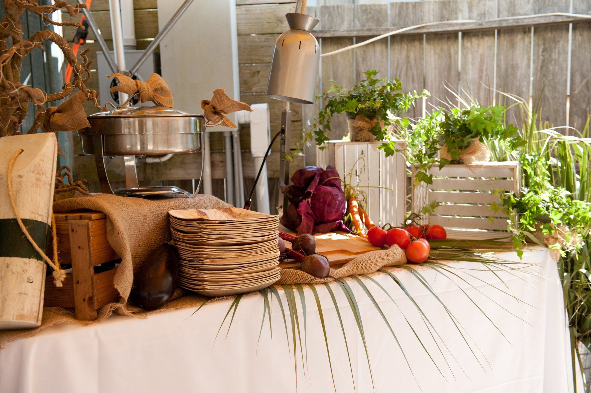 A table with plates , vegetables , and a pot on it.