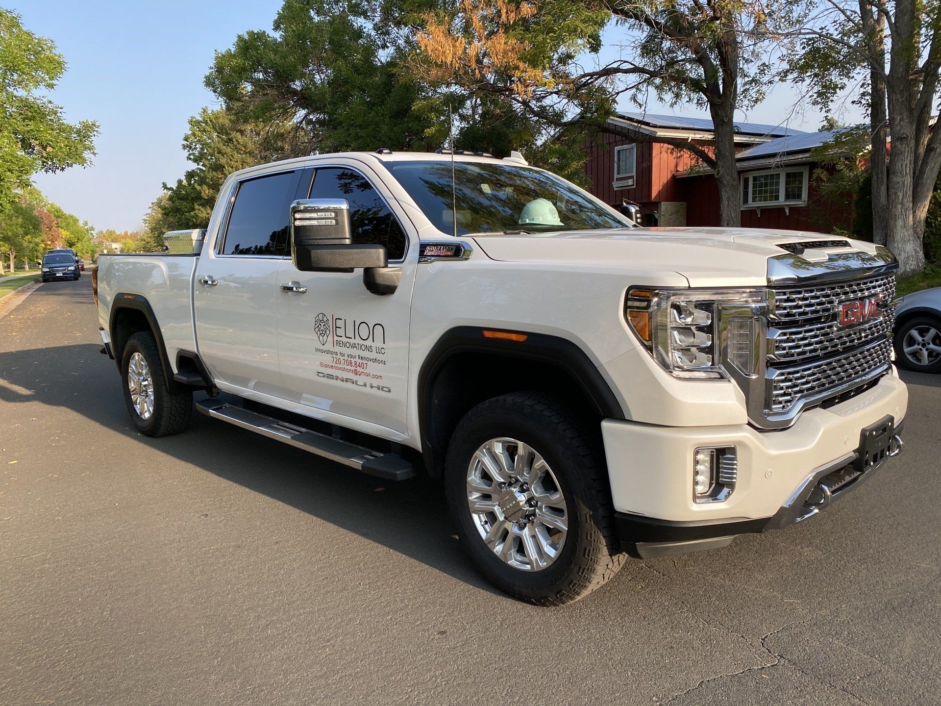 a white gmc truck is parked on the side of the road .